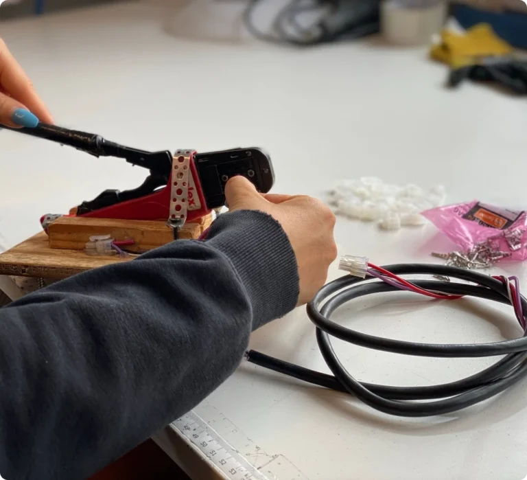 Noggrant arbete med ledningar och komponenter under pågående kablageproduktion i Bålsta